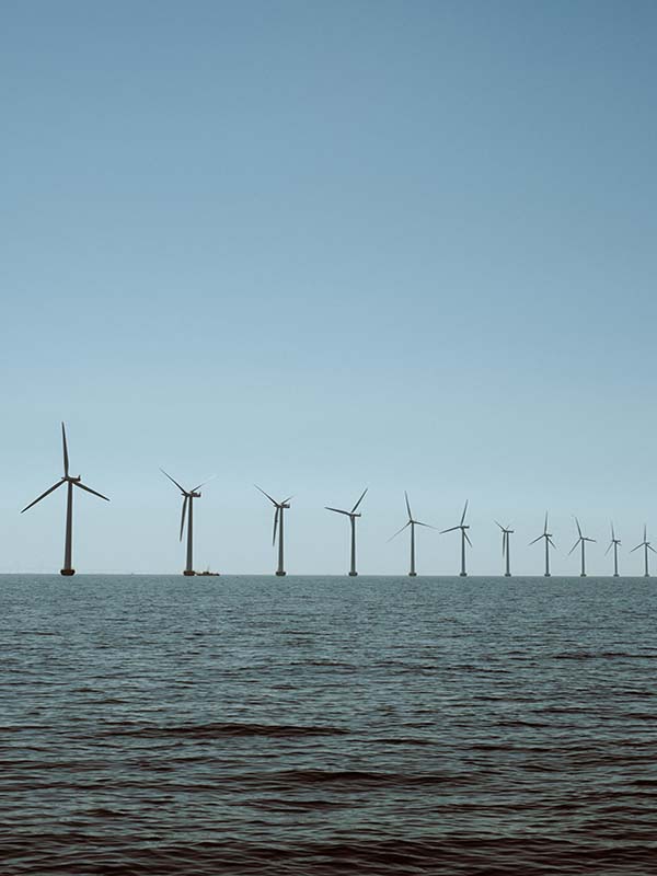 Offshore wind farm with multiple turbines in a calm ocean under a clear sky